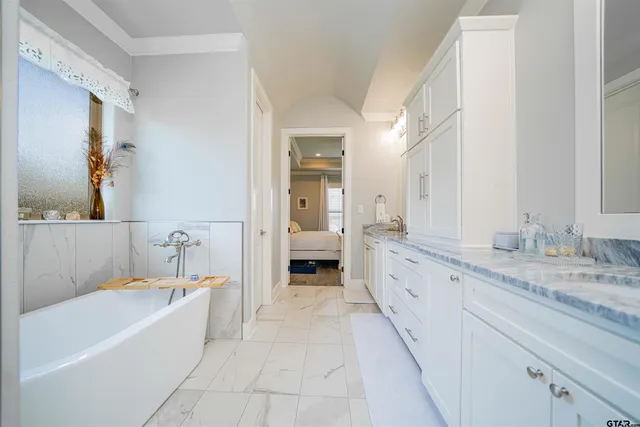 a spacious en suite bathroom with a granite countertop tub double and sink