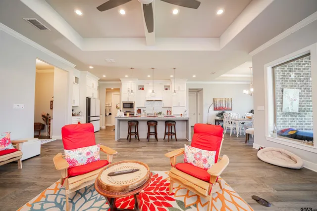 a living room with lots of furniture and a dining table with wooden floor
