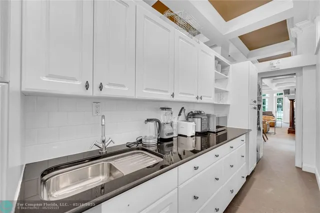 a kitchen with granite countertop white cabinets and sink