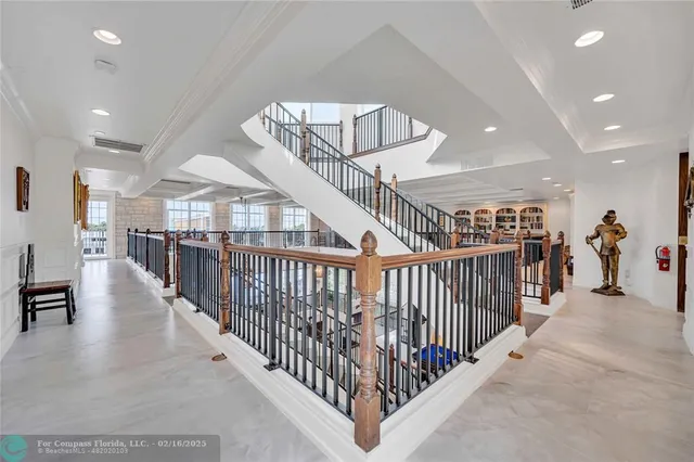 a view of interior of a hall with wooden floor and stairs