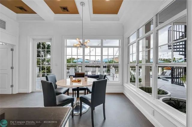 a dining room with furniture a chandelier and wooden floor
