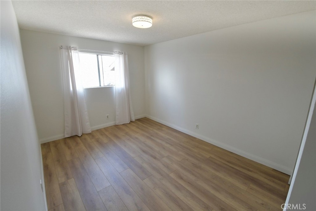 22346 Harbor Ridge Lane, Unit 4 Torrance, CA 90502 - Photo 14 of 34 an empty room with wooden floor and windows