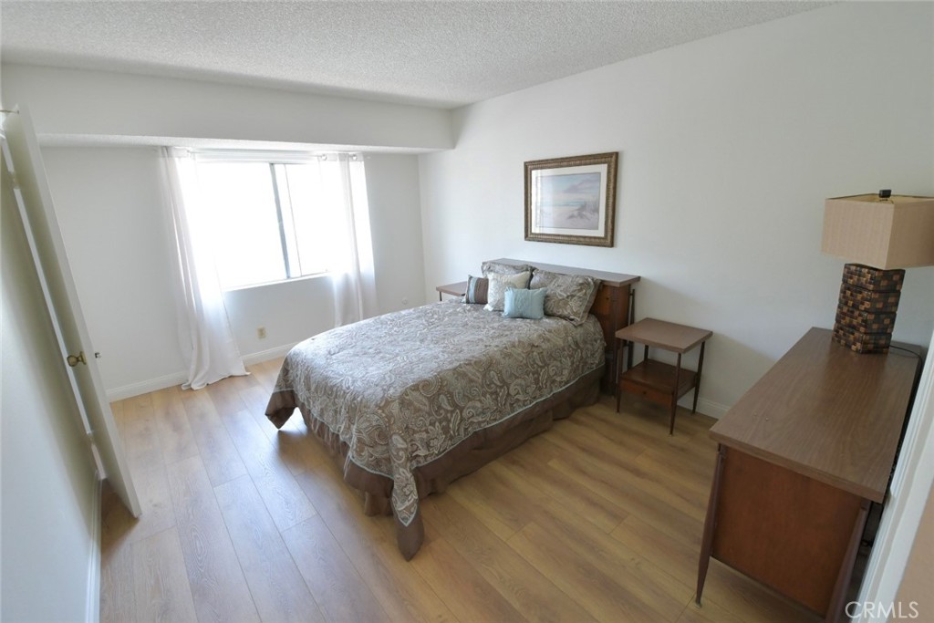 22346 Harbor Ridge Lane, Unit 4 Torrance, CA 90502 - Photo 10 of 34 a bedroom with a bed and wooden floor