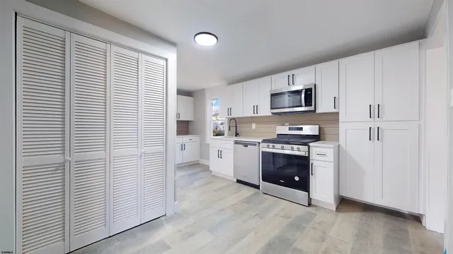a kitchen with stainless steel appliances a refrigerator and a stove top oven