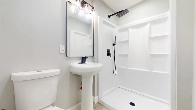 a bathroom with a sink a toilet and shower