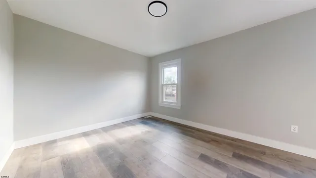 a view of room with window and wooden floor