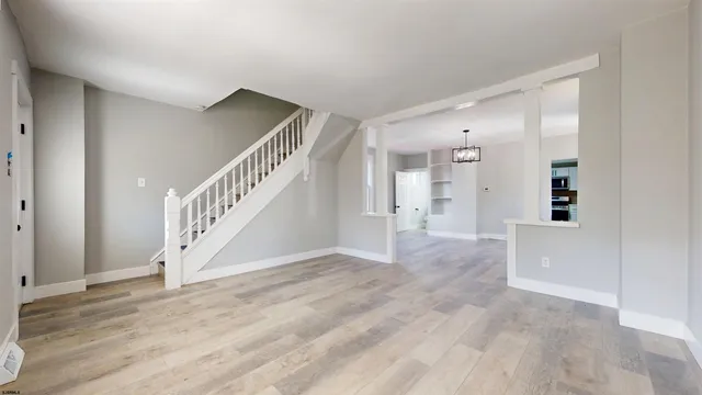 a view of an entryway with wooden floor and a livingroom view