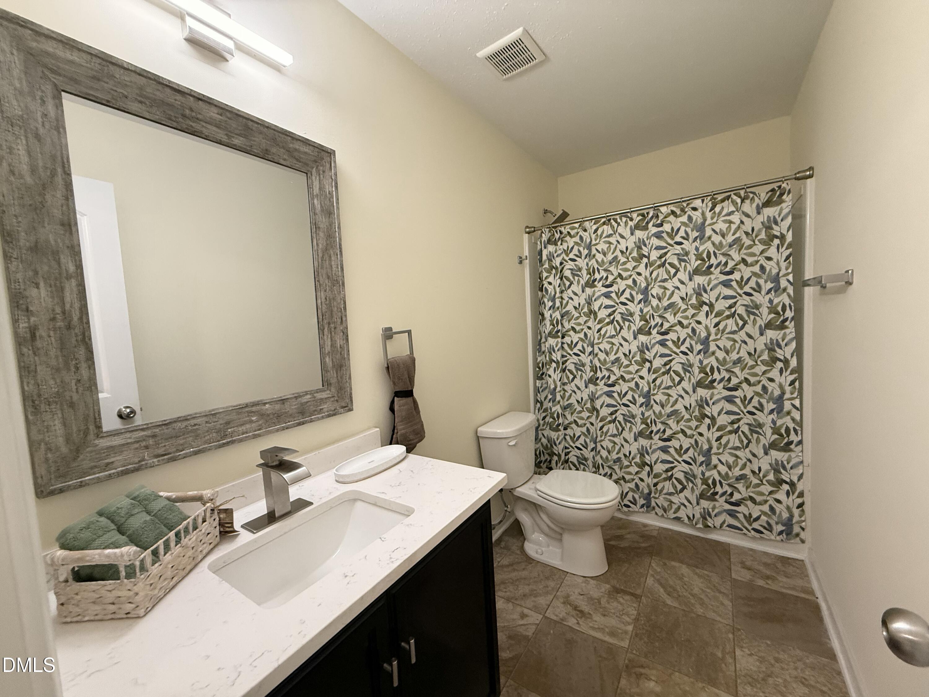 62 West Boulder Road Henderson, NC 27537 - Photo 18 of 34 a bathroom with a sink a toilet and shower curtain