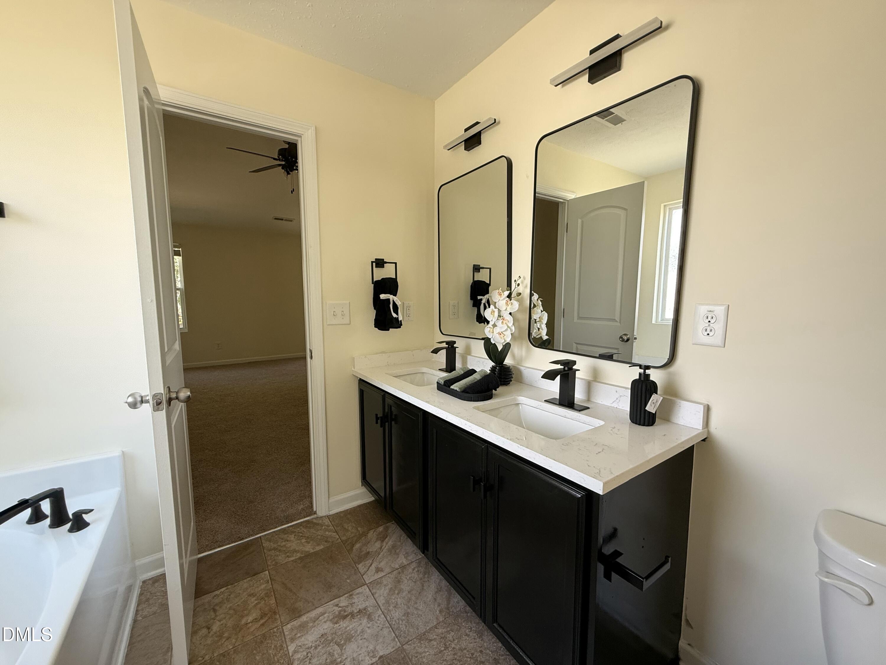 62 West Boulder Road Henderson, NC 27537 - Photo 30 of 34 a bathroom with a sink vanity and a mirror
