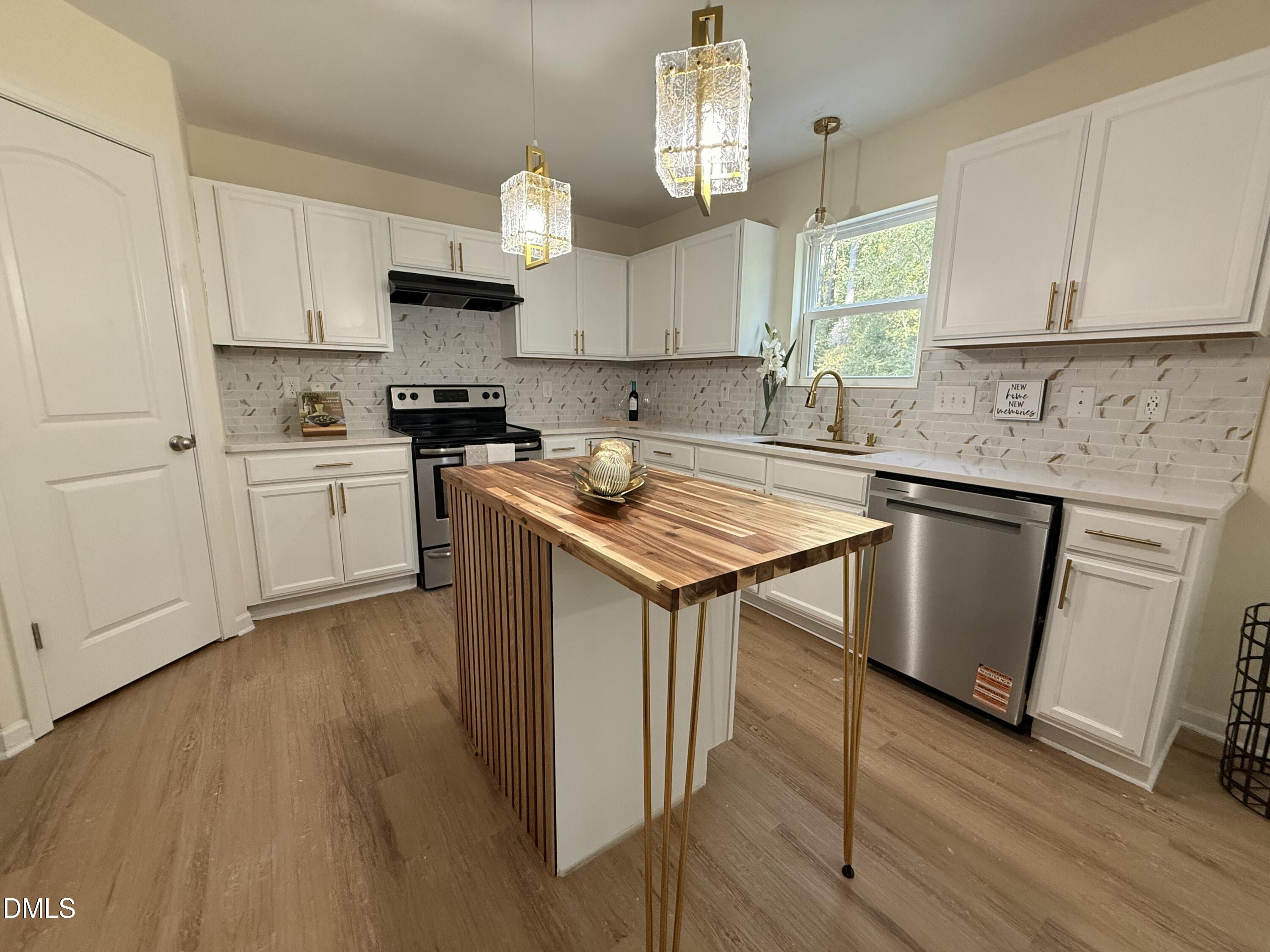 62 West Boulder Road Henderson, NC 27537 - Photo 6 of 34 a kitchen with a sink a stove a microwave and cabinets