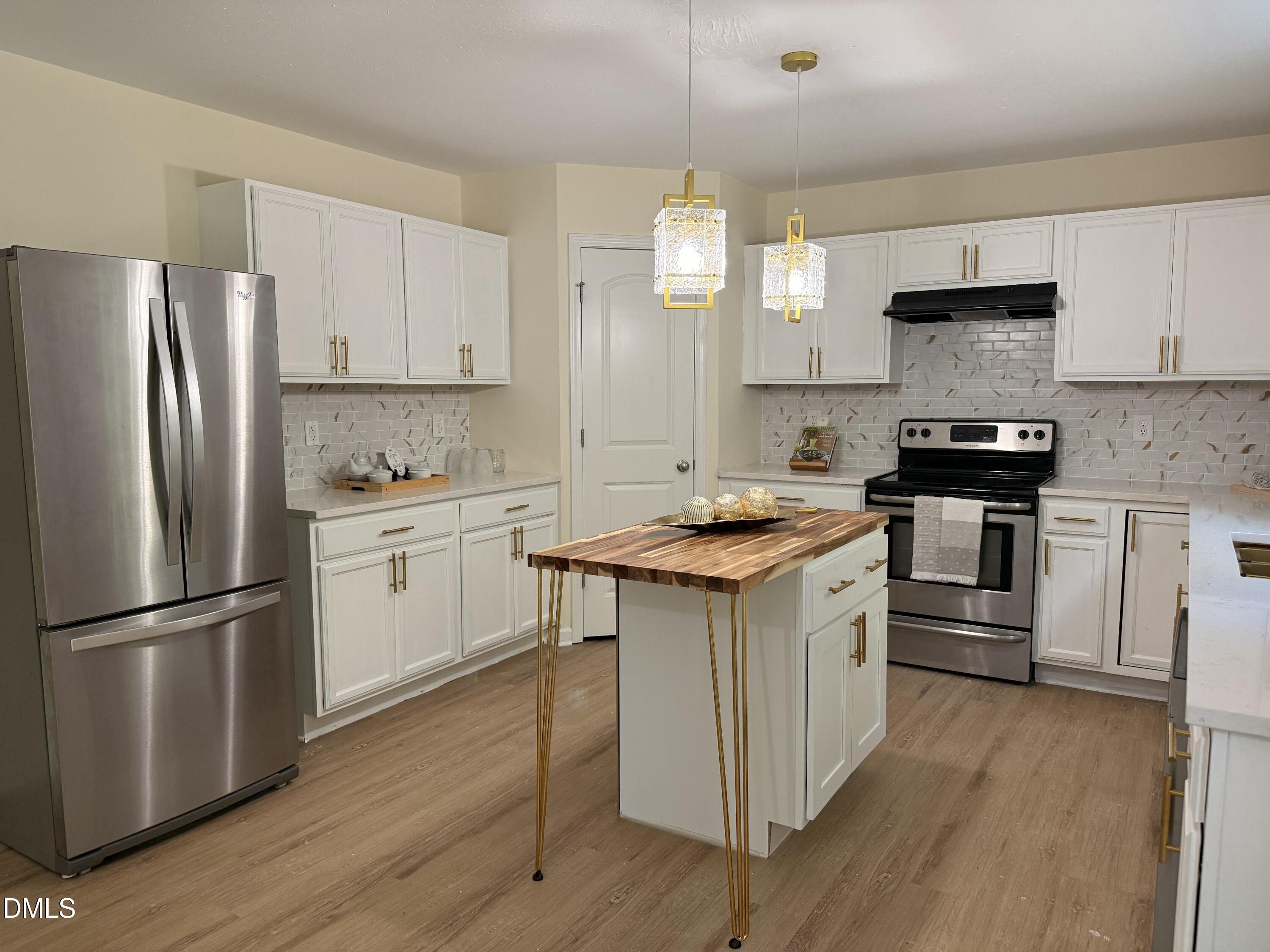 62 West Boulder Road Henderson, NC 27537 - Photo 7 of 34 a kitchen with white cabinets stainless steel appliances and wooden floor