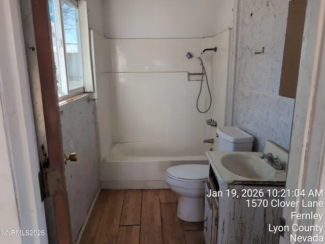a bathroom with a granite countertop bathtub shower sink and toilet