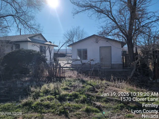 a backyard of a house with lots of plants and trees