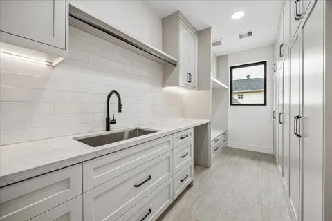 a kitchen with a refrigerator sink and cabinets