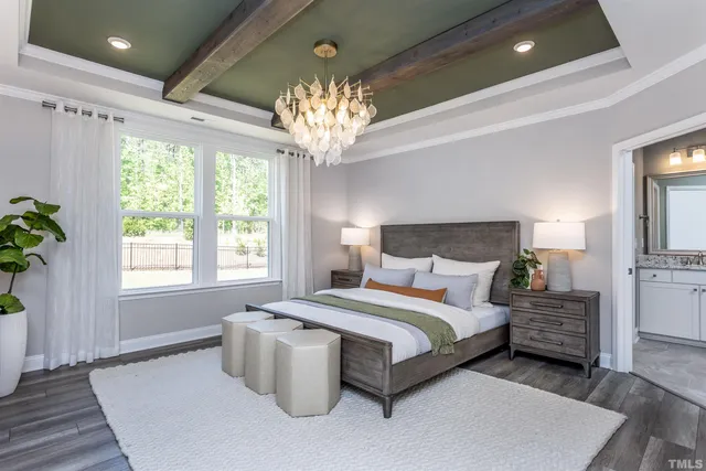a spacious bedroom with a bed and a chandelier