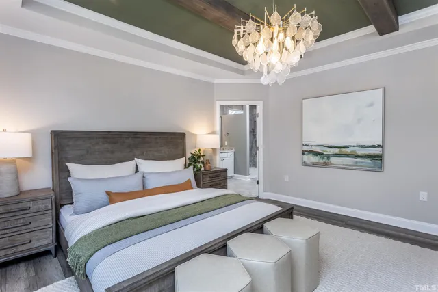 a bedroom with a large bed and a chandelier