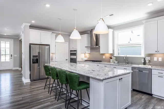 a kitchen with stainless steel appliances granite countertop a kitchen island a stove a table and chairs in it