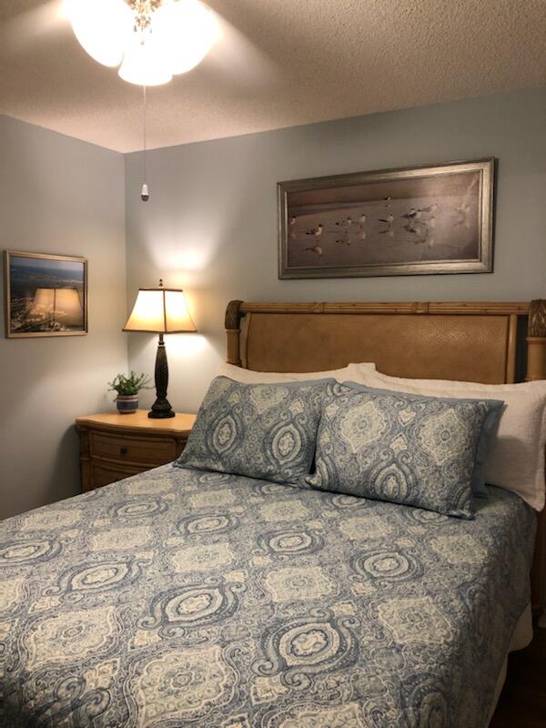 6021 Southeast Landing Way, Unit BLDG 2 #2 Stuart, FL 34997 - Photo 12 of 35 a bedroom with a large bed and a lamp