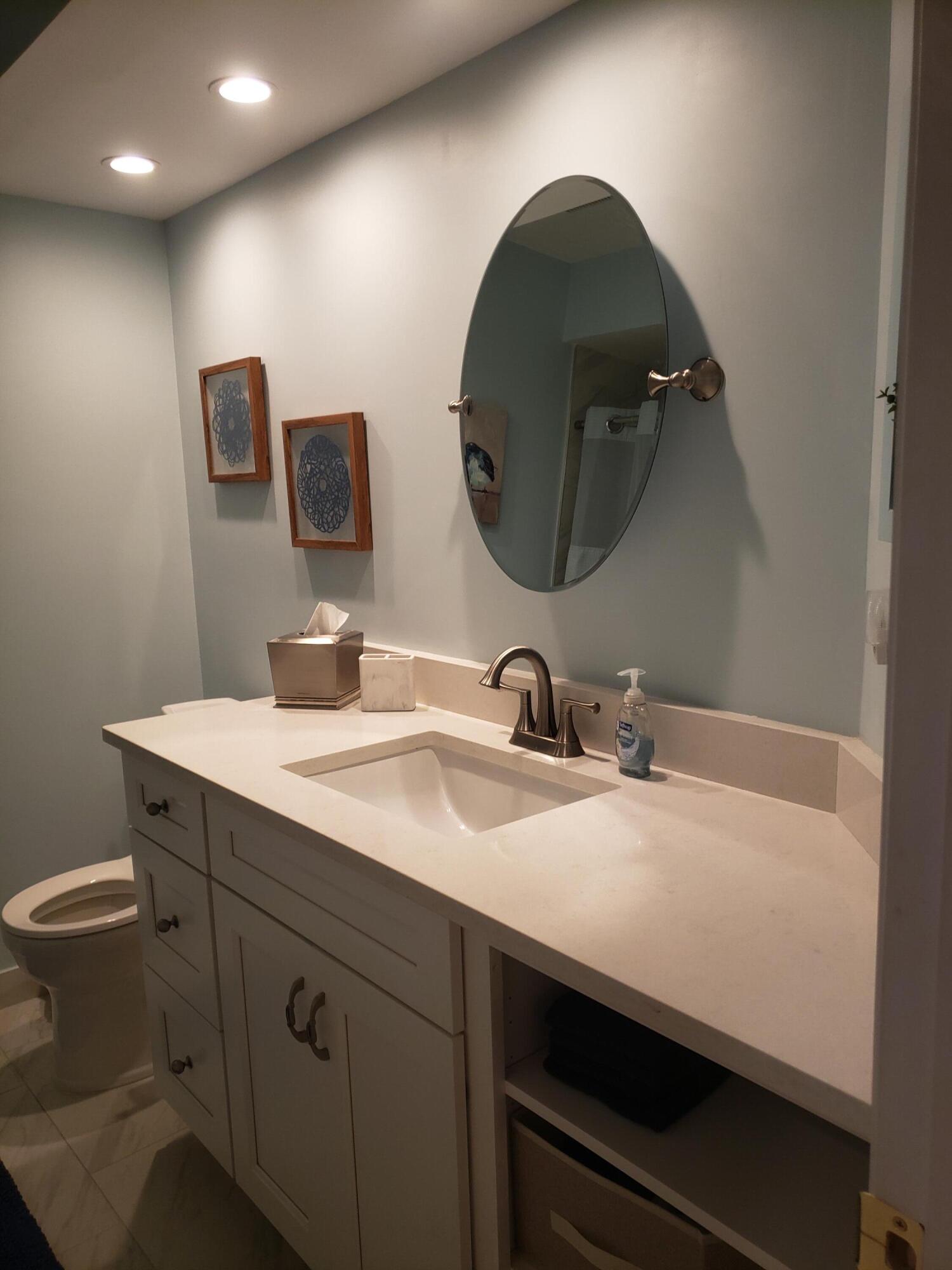 6021 Southeast Landing Way, Unit BLDG 2 #2 Stuart, FL 34997 - Photo 15 of 35 a bathroom with a double vanity sink and a mirror