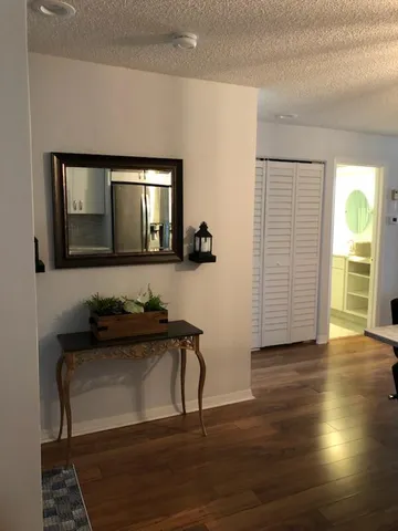 a view of a room with wooden floor lounge chair and a view of bedroom