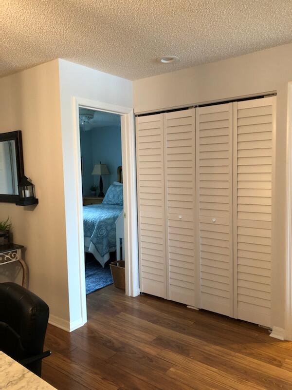 6021 Southeast Landing Way, Unit BLDG 2 #2 Stuart, FL 34997 - Photo 20 of 35 a view of a room with wooden floor lounge chair and a view of bedroom