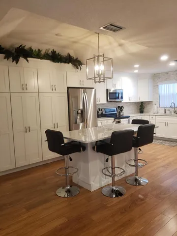 a kitchen with stainless steel appliances kitchen island granite countertop a table and chairs in it