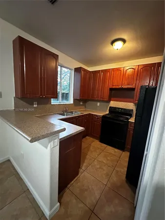 a kitchen with granite countertop wood cabinets and stainless steel appliances