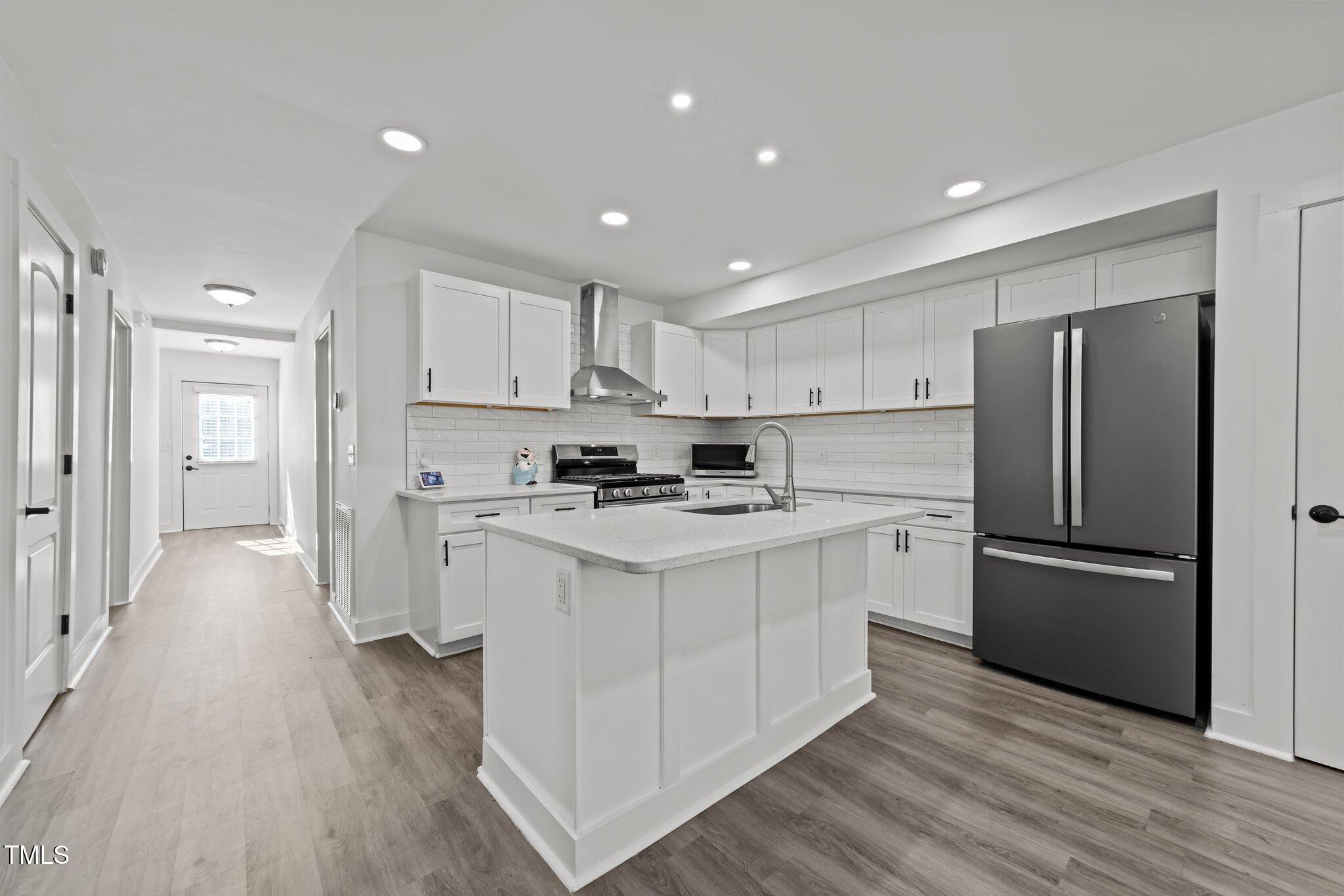 819 Cumberland Street Raleigh, NC 27610 - Photo 12 of 32 a kitchen with white cabinets and stainless steel appliances