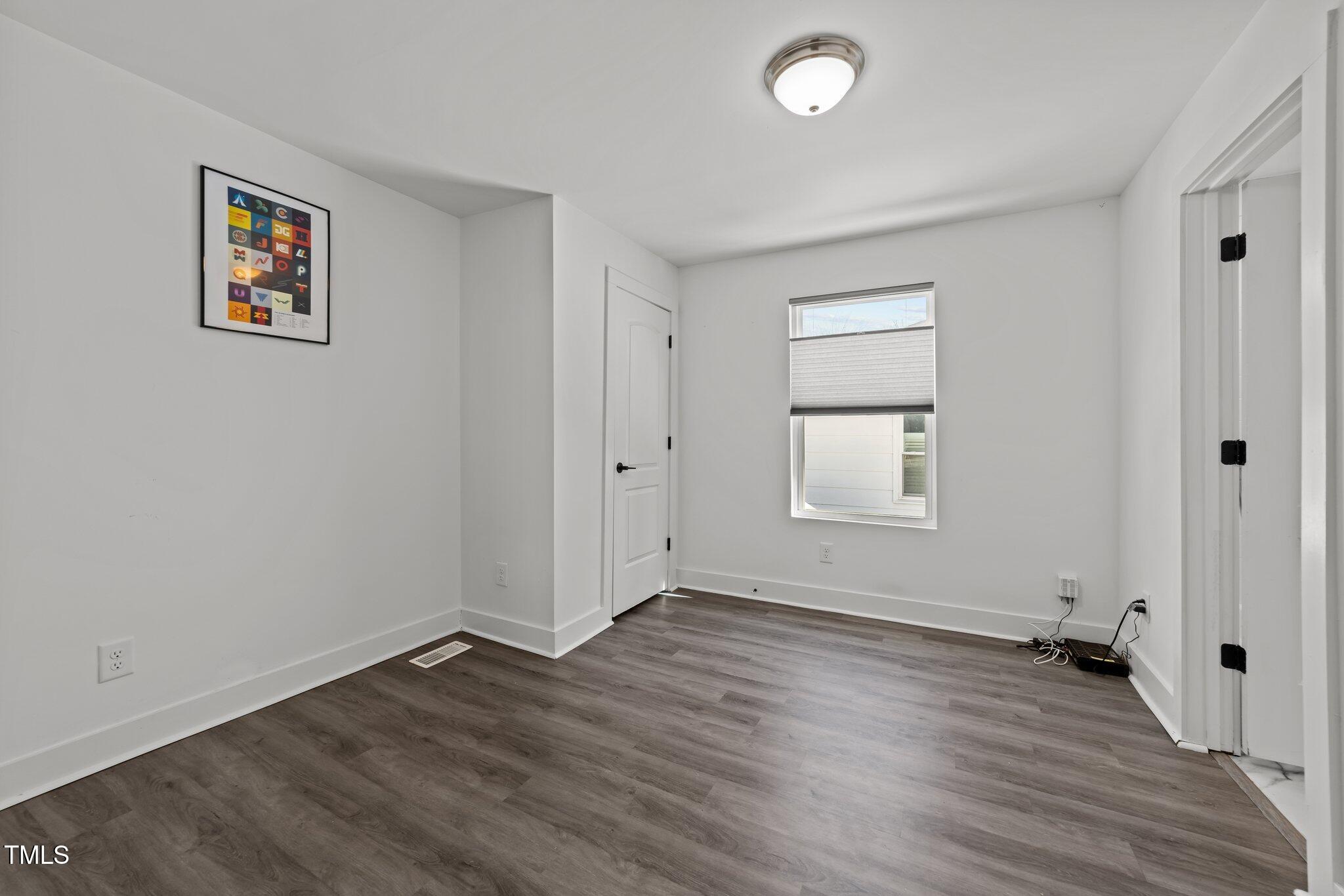819 Cumberland Street Raleigh, NC 27610 - Photo 15 of 32 an empty room with wooden floor and windows