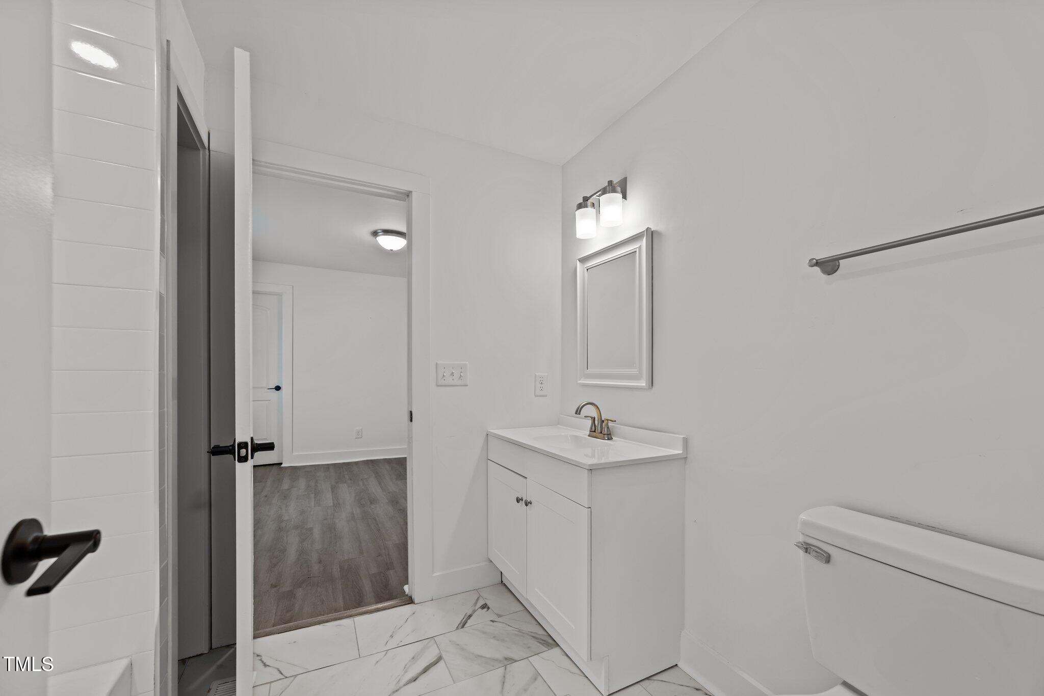 819 Cumberland Street Raleigh, NC 27610 - Photo 17 of 32 a bathroom with a sink a toilet and mirror