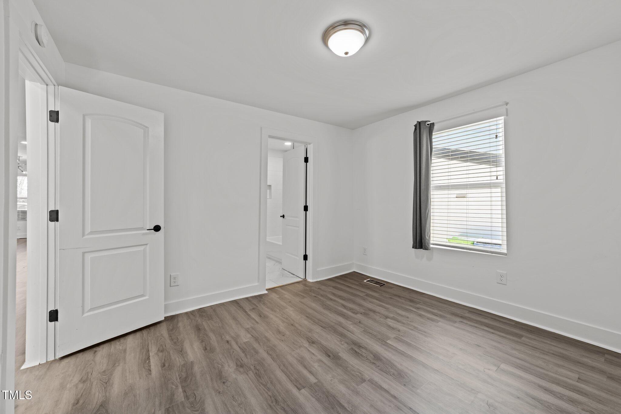 819 Cumberland Street Raleigh, NC 27610 - Photo 20 of 32 a view of an empty room with wooden floor and a window