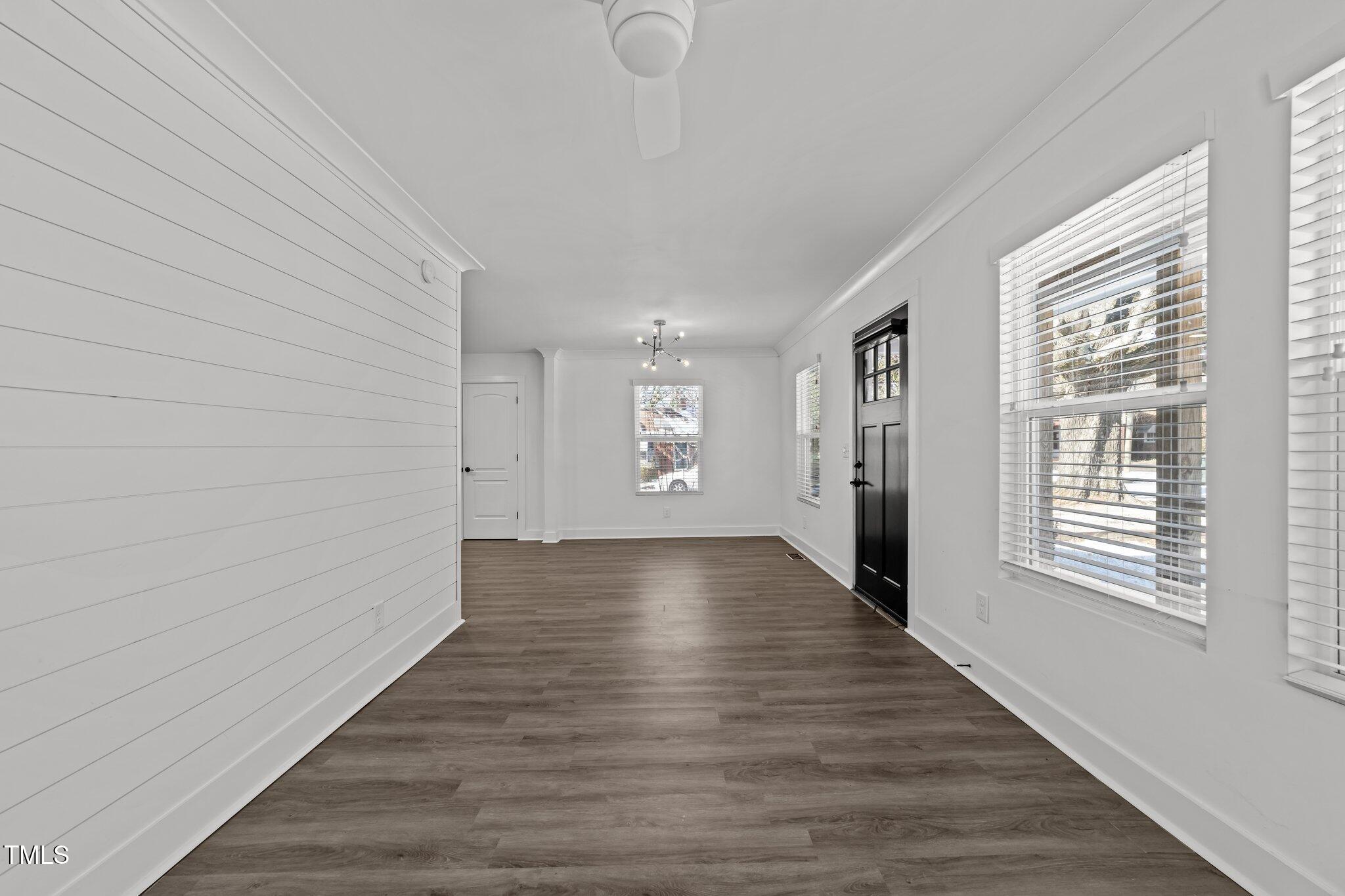 819 Cumberland Street Raleigh, NC 27610 - Photo 7 of 32 a view of an empty room with wooden floor and a window