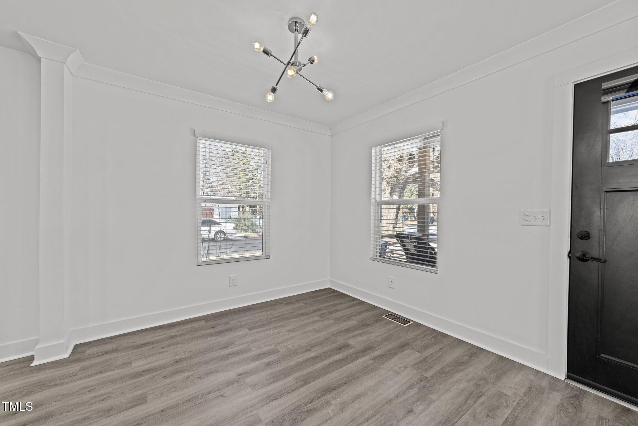 819 Cumberland Street Raleigh, NC 27610 - Photo 10 of 32 a view of an empty room with a window and wooden floor