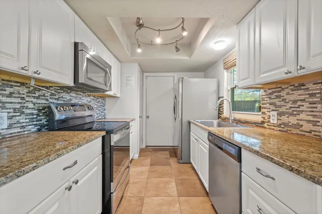 a kitchen with stainless steel appliances granite countertop a sink stove and cabinets