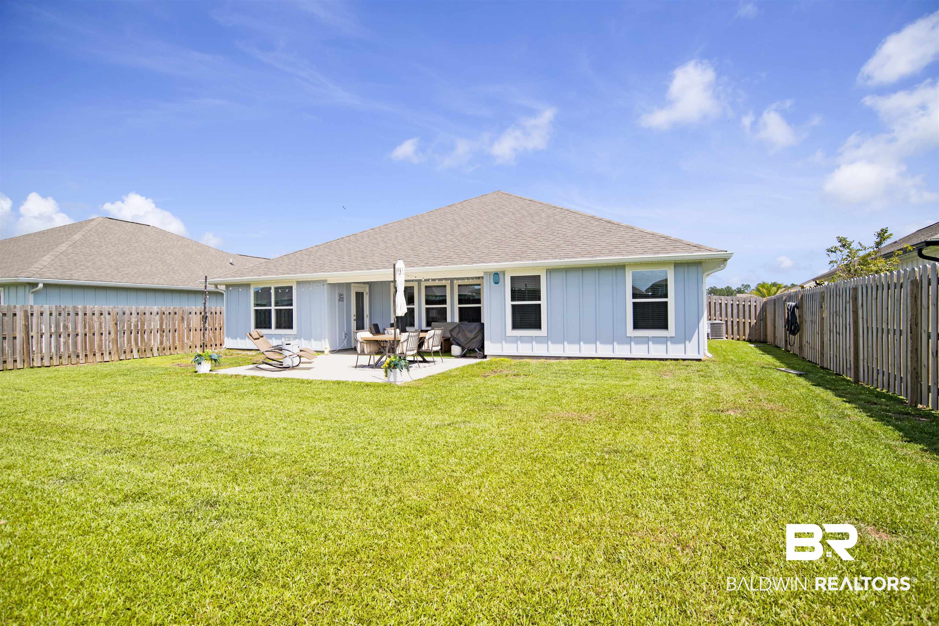 22301 Early Dawn Circle Foley, AL 36535 - Photo 37 of 45 Rear exterior featuring light blue siding, a shingle roof, and multiple windows with white trim