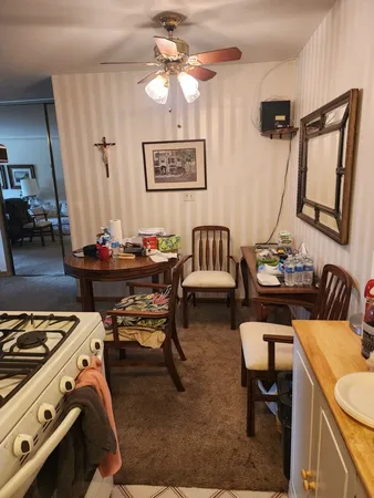 a view of a dining room with furniture and a chandelier fan