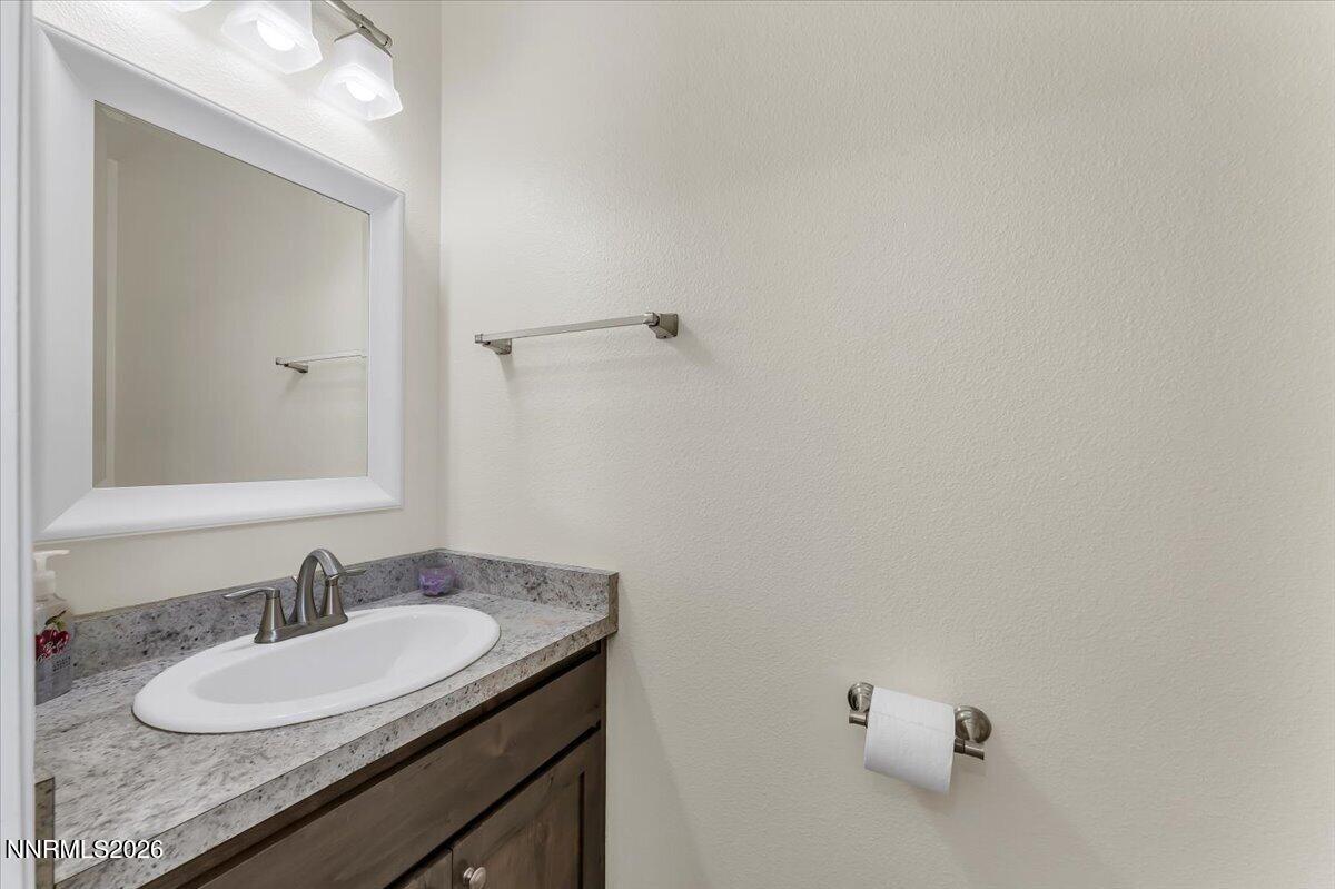 1197 Sky Ridge Drive Fallon, NV 89406 - Photo 28 of 79 a bathroom with a granite countertop sink and a mirror