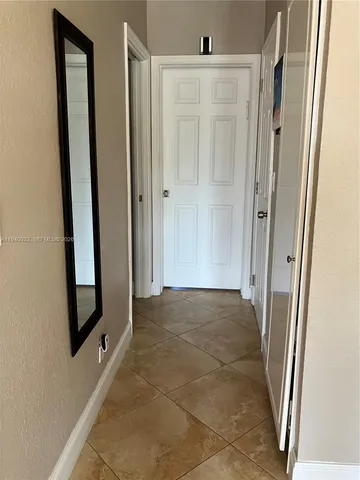 a view of a hallway with wooden floor and brick walls