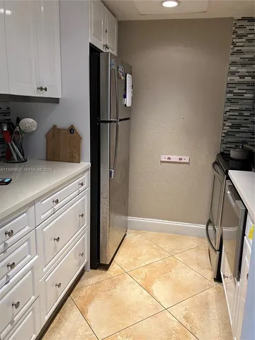 a kitchen with a refrigerator and cabinets