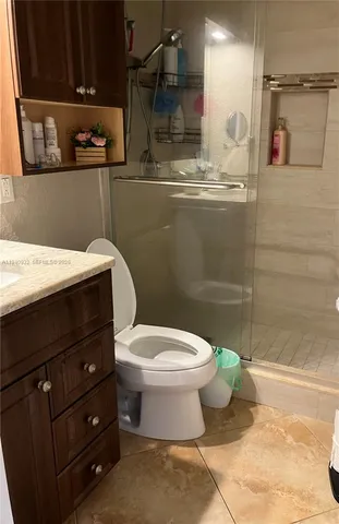 a bathroom with a granite countertop toilet and sink