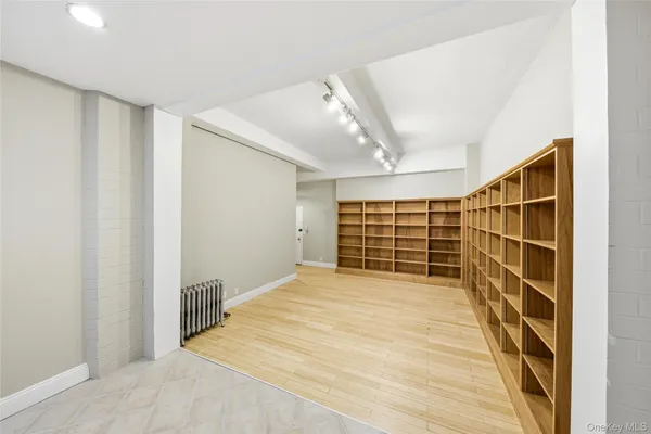 a view of empty room with wooden floor and windows