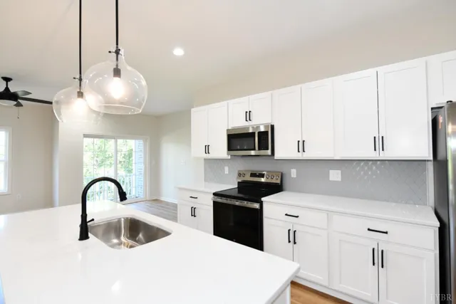 a kitchen with white cabinets a sink and appliances