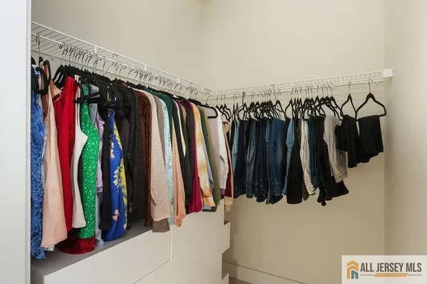 a view of walk in closet with clothes and shoes