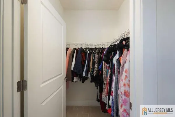 a view of walk in closet with clothes