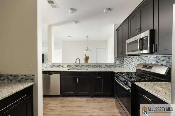 a kitchen with stainless steel appliances granite countertop a stove and a microwave