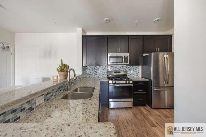 421 Tavern Road Monroe Township, NJ 08831 - Photo 6 of 27 a kitchen with a refrigerator sink and stainless steel appliances
