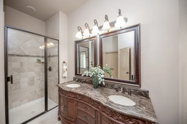 a bathroom with a tub shower and mirror