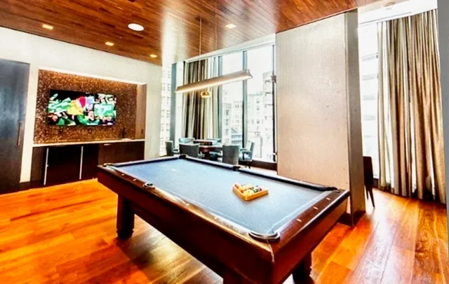 a room with pool table and windows