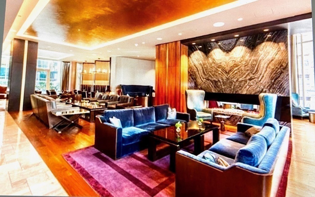 1 Franklin Street, Unit 1205 Boston, MA 02110 - Photo 14 of 16 a living room with furniture and a floor to ceiling window