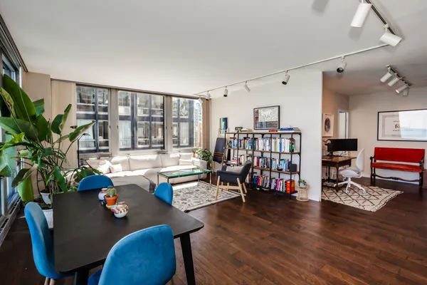 a living room with furniture and a table with wooden floor